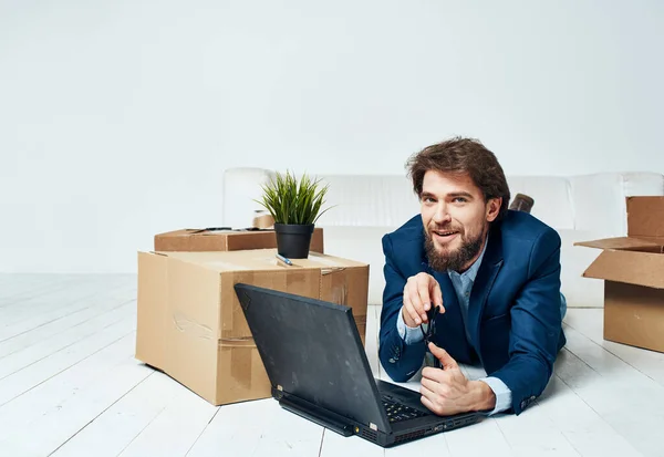 Un homme se trouve devant un ordinateur portable boîtes avec des choses déballer Office homme d'affaires professionnel — Photo