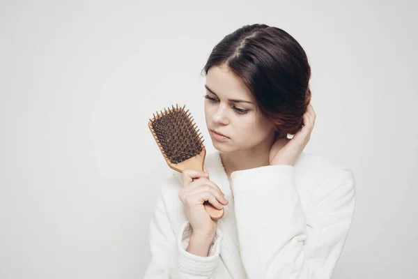 Mulher segurando um pente na mão e emaranhado problemas de saúde fragilidade do cabelo — Fotografia de Stock