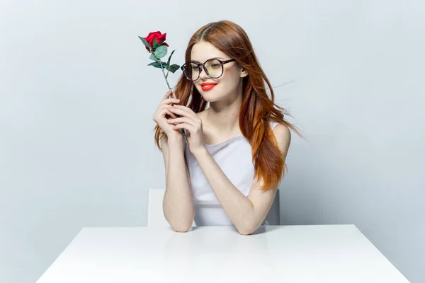 Uśmiechnięta kobieta z różanym kwiatem w rękach praca biurko emocje prezent luksus — Zdjęcie stockowe