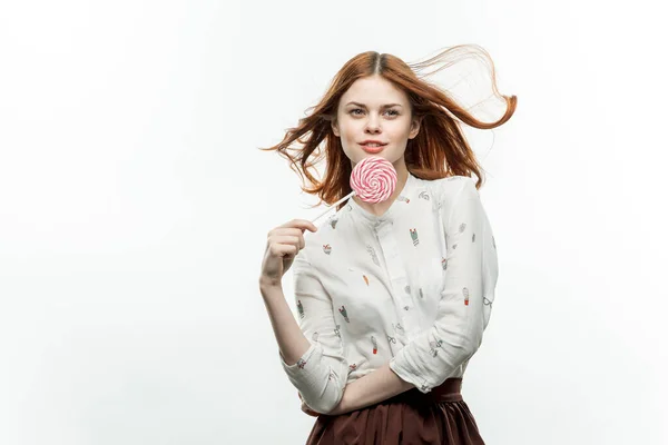하얀 셔츠를 입고 사탕 사탕을 손에 쥐고 있는 여자 — 스톡 사진