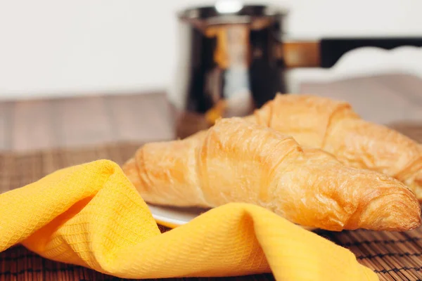 Fresh croissants on a saucer table setting breakfast cup with drinks — Stock Photo, Image