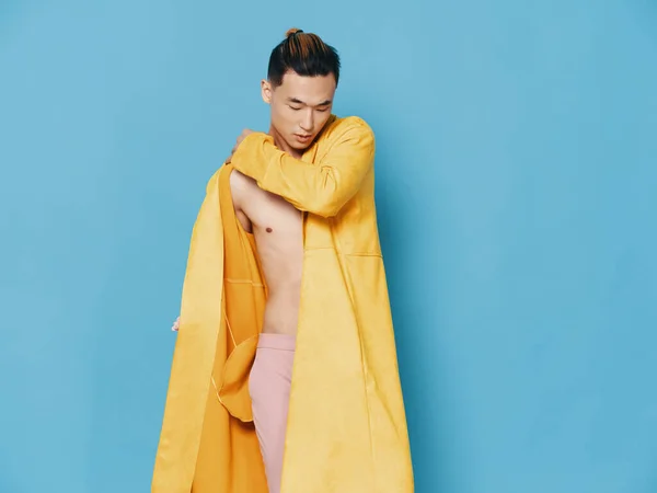 Félmeztelen ázsiai férfi sárga kabátban kék háttér frizura modell — Stock Fotó