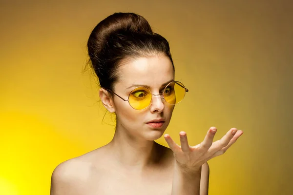 Красивая женщина в желтых очках голые плечи жесты с эмоциями рук — стоковое фото
