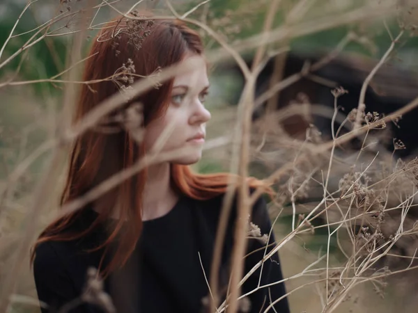 Žena v blízkosti suchých větví stromů na podzim v lese — Stock fotografie