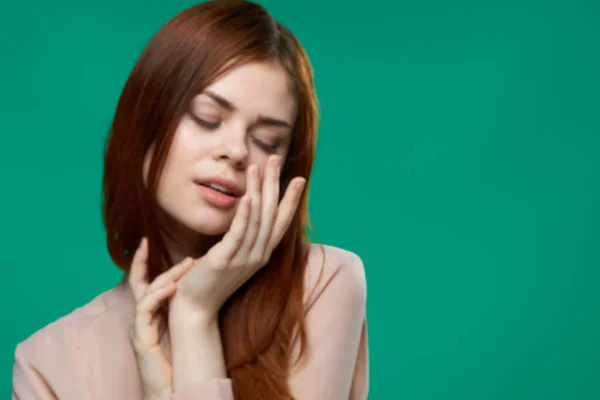Attraktive Frau hält Hände in der Nähe Glamour Gesicht grünen Hintergrund — Stockfoto