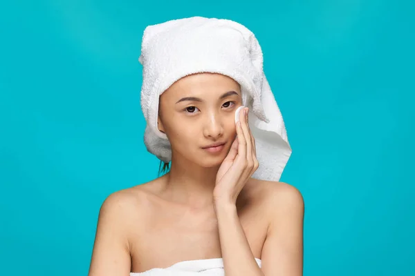 Vrouw met blote schouders aziatische verschijning schoon huid veegt haar gezicht na make-up — Stockfoto