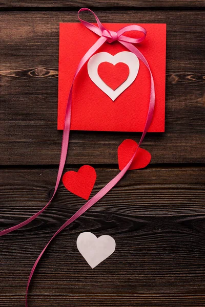 Tarjeta de felicitación con corazón regalo día de San Valentín decoración fondo de madera — Foto de Stock