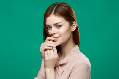 Güzel kadın pembe gömlek, çekici. Gülümse, yeşil arka plan.