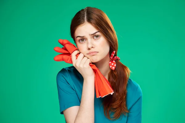 Hausfrau hält Handschuhe in den Händen Grüner Hintergrund häusliche Pflege — Stockfoto