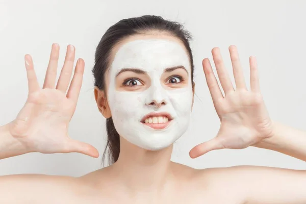 Morena alegre hombros desnudos crema mascarilla facial tratamientos de cuidado de la piel —  Fotos de Stock