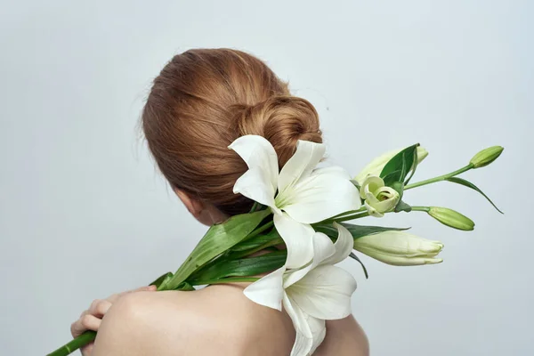 Señora con un ramo de flores blancas sobre un retrato de fondo gris vista recortada de cerca — Foto de Stock