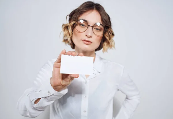 Geschäftsfrau mit Visitenkarte auf hellem Hintergrund — Stockfoto