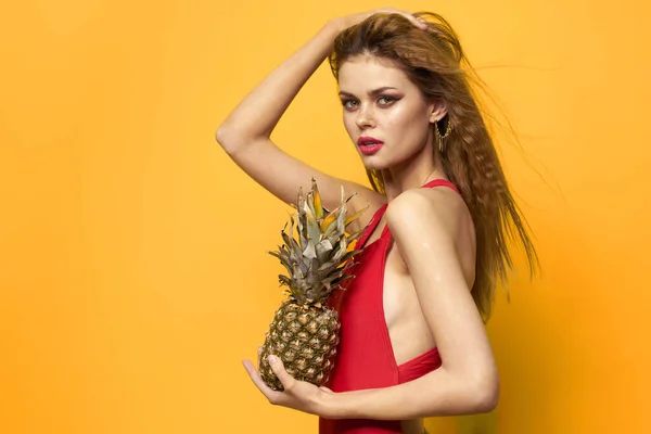 Kvinna med ananas i händerna vit t-shirt Exotisk sommar kul gul bakgrund — Stockfoto