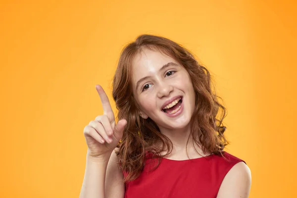 Menina com cabelo encaracolado vestido vermelho diversão emoções infantis fundo amarelo — Fotografia de Stock