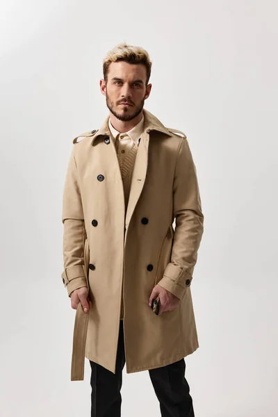 Стильний молодий чоловік в бежевому пальто і штани обрізаний вид светр моделі — стокове фото