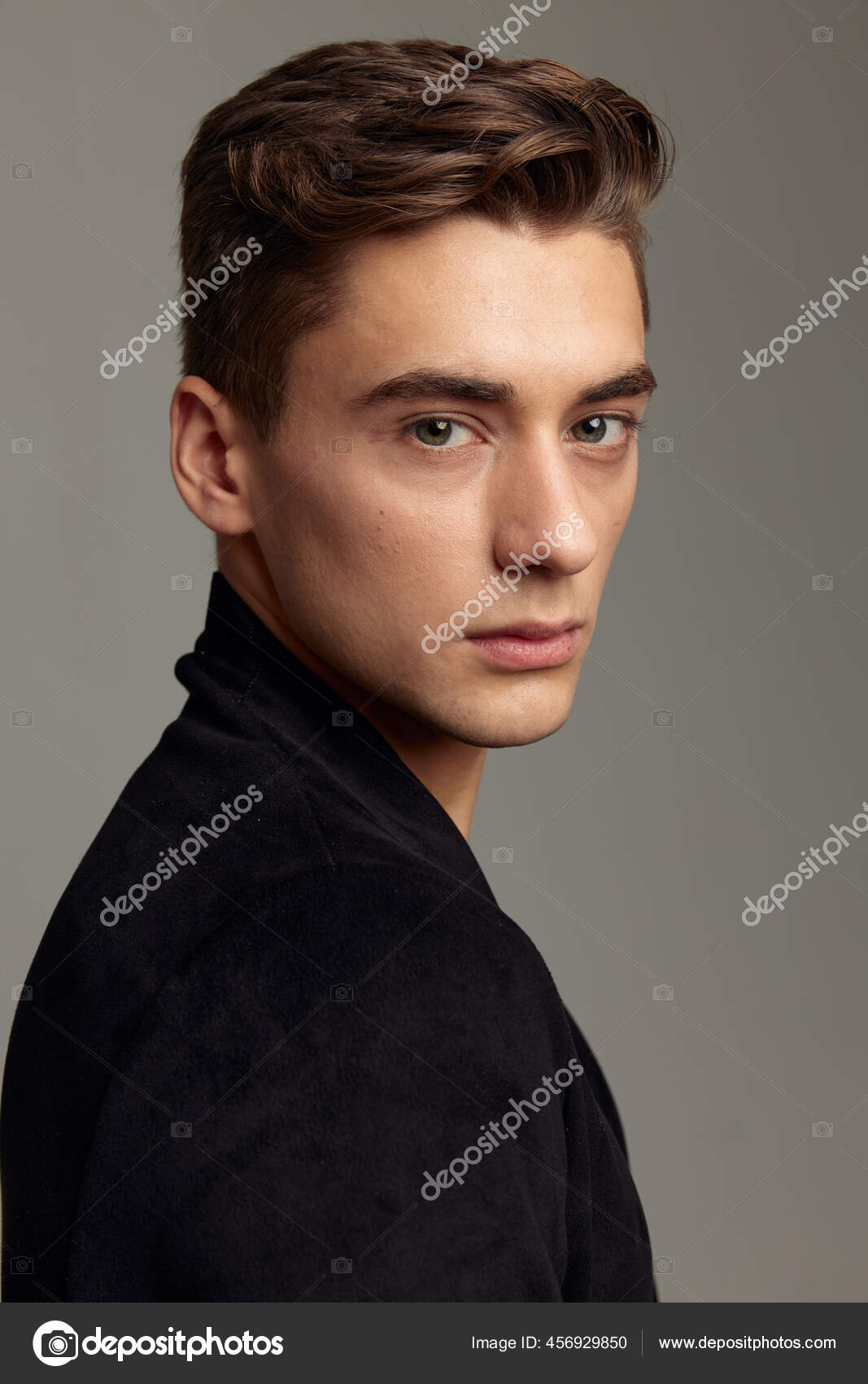 Handsome young man with dark beard stubble and modern hairstyle in serious  studio portrait with cold tones and dramatic lighting Stock Photo - Alamy