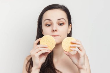 Güzel esmer, çıplak omuzlu, elinde süngerle kırpık manzaralı.