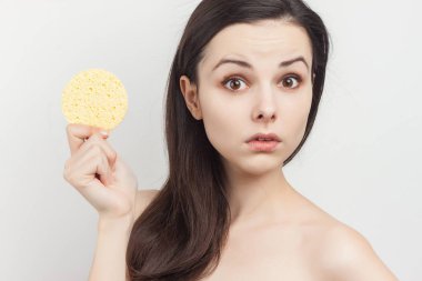 Güzel esmer, çıplak omuzlu, elinde süngerle kırpık manzaralı.