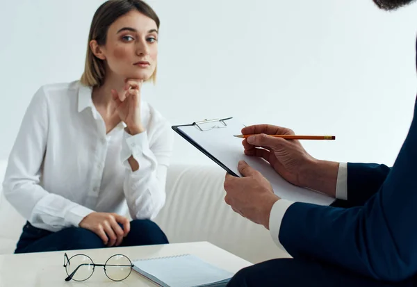 Een man met documenten en een vrouw op de bank aan tafel binnen personeel psycholoog receptie arts — Stockfoto