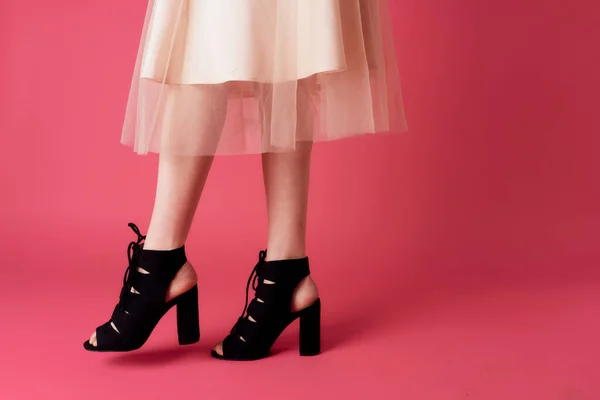 Piedi femminili nero tacchi alla moda scarpe fascino rosa sfondo — Foto Stock