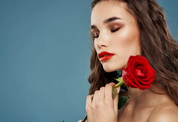 Portré egy gyönyörű nő egy piros virág a kék háttér és esti smink modell — Stock Fotó