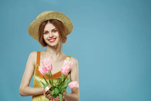 Mulher alegre em um buquê de chapéu flores feriado presente charme azul fundo — Fotografia de Stock