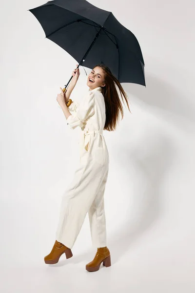 明るい女性保持傘で彼女の手ホワイトジャンプスーツファッションスタジオブーツ — ストック写真