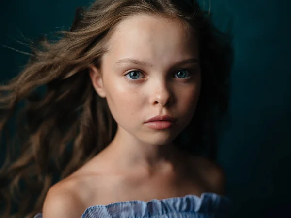 Mooi klein meisje in een sundress op een donkere achtergrond close-up portret — Stockfoto
