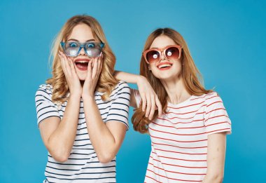 Çizgili tişörtlü, güneş gözlüğü takan neşeli kadınlar moda iletişim stüdyosu
