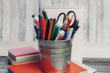 Tahta bir masa ve kırmızı bir defter üzerinde demir kumaş kırtasiyesi.