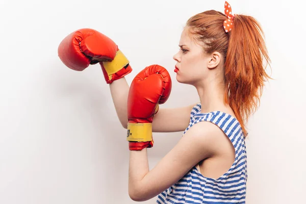 Eine Frau boxt auf hellem Hintergrund helle Make-up gestreifte T-Shirt-Frisur — Stockfoto