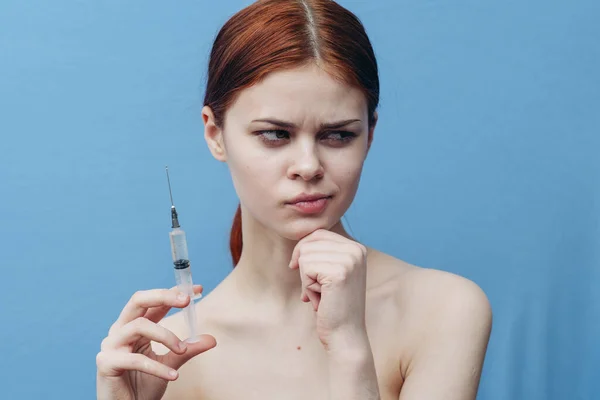 Spruta i kvinna hand på blå bakgrund injektion föryngring botox beskärd vy — Stockfoto