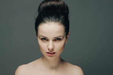 Çıplak omuzlu, temiz cilt bakımlı bir kadın.