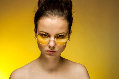 Esmer, sarı gözlüklü, çıplak omuzlu, cilt duyguları olan.