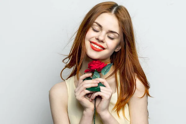 Mulher sorridente segurando rosa flor em mãos charme lábios vermelhos olhar atraente — Fotografia de Stock