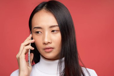 Güzel esmer, telefon teknolojisiyle konuşuyor. Yakın plan kırmızı arka plan.