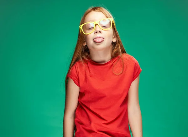 Schattig meisje met rood haar geel bril emoties studio groen achtergrond — Stockfoto