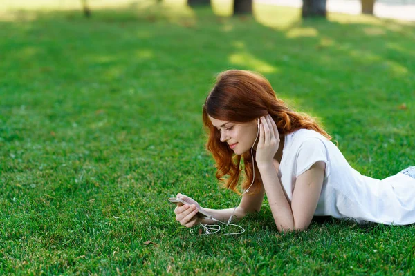 Mujer bonita se encuentra en el césped en el parque al aire libre recreación —  Fotos de Stock