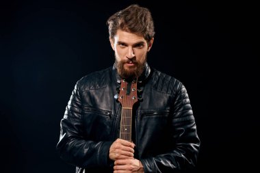 Elinde gitar olan bir adam deri ceketli müzik performansı rock yıldızı modern tarz koyu arkaplan