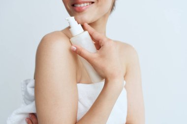 Beyaz havluyla güzel bir kadın çıplak omuzlar losyon temiz cilt hijyeni