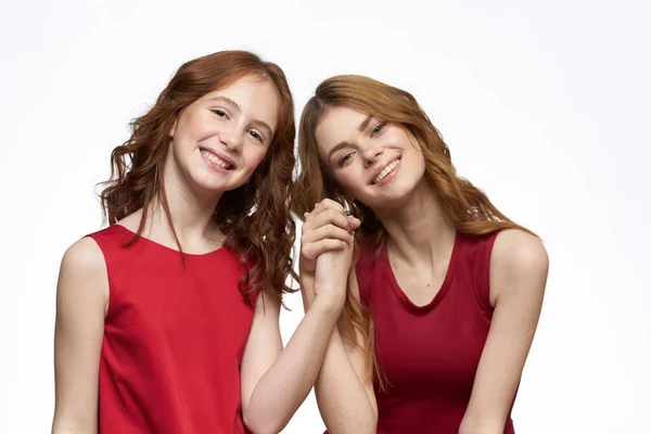 ママと娘の赤いドレス抱擁家族の喜び友情 — ストック写真