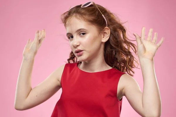 Allegro bambina infanzia occhiali scuri rosso abito stile di vita rosa sfondo — Foto Stock