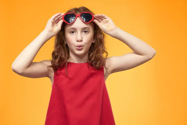 Vidám kislány piros ruha göndör haj sárga háttér gyermekkor — Stock Fotó