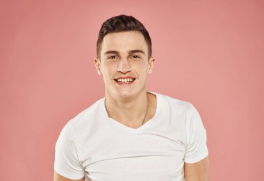 Beyaz tişörtlü yakışıklı adam duygular pembe arka plan
