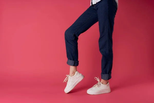 Женские ноги белые кроссовки стиль улицы моды розовый фон — стоковое фото