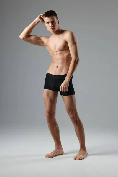 Sporty man in black shorts posing on isolated background — Stock Photo, Image