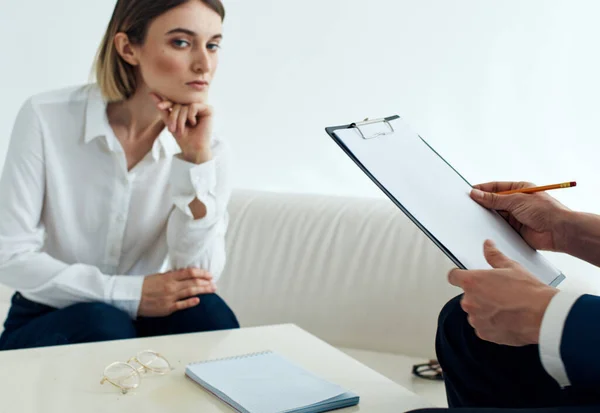 Een man met documenten en een vrouw op de bank aan tafel binnen personeel psycholoog receptie arts — Stockfoto