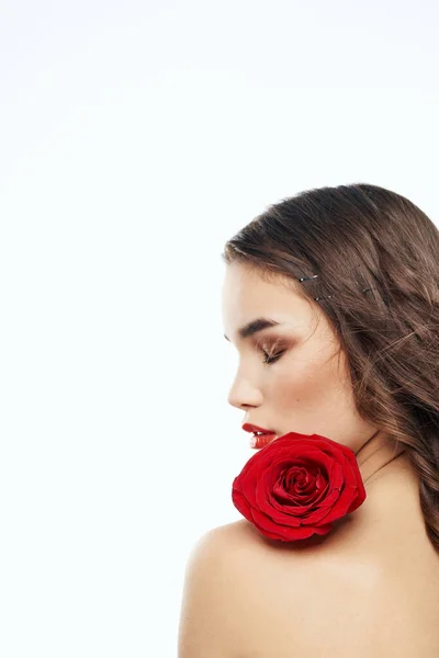 Zadní pohled na atraktivní brunetku s červenou růží na nahém rameni — Stock fotografie