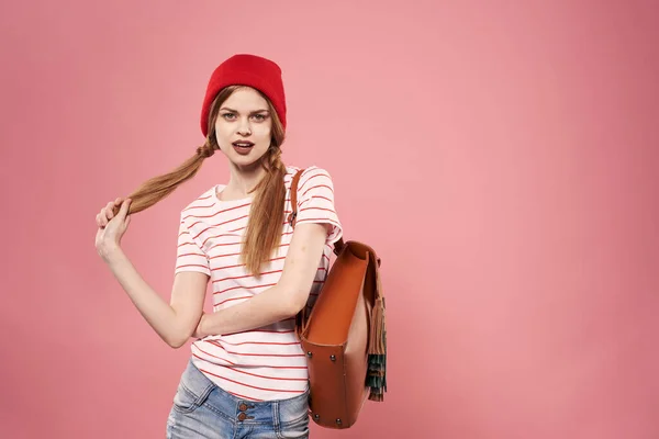 Mulher glamourosa na moda em vermelho chapéu mochila estudante hipster rosa fundo — Fotografia de Stock