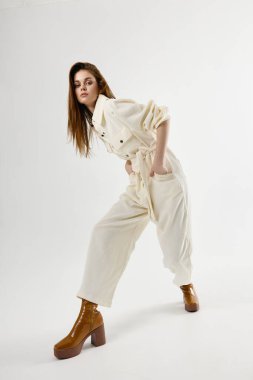 Takım elbiseli şık bir kadın. Stüdyoda poz veriyor.